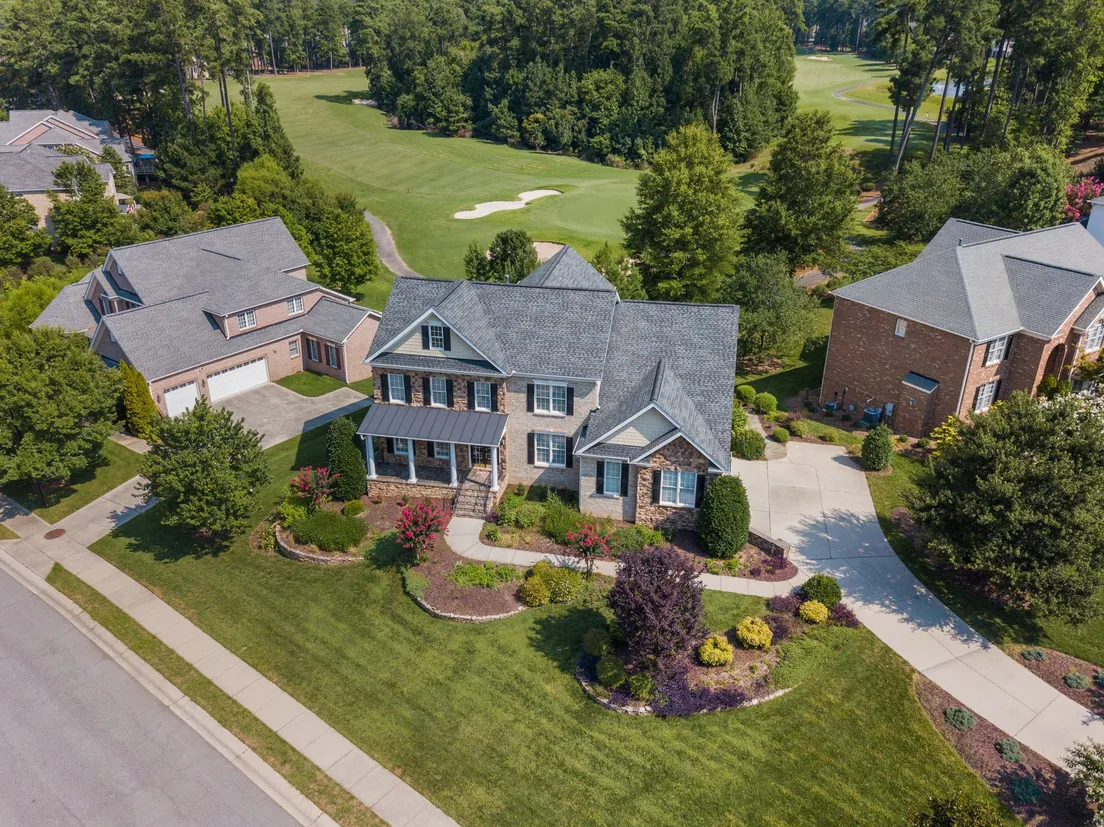 Aerial view of a house with a freshly mowed, manicured lawn